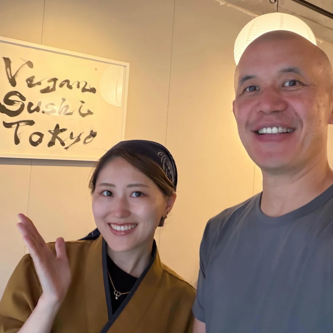 店内のサインの前で、お客様と